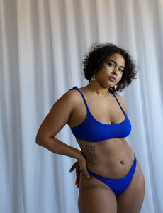 Deep blue bikini top with adjustable straps that ties on the shoulder 
